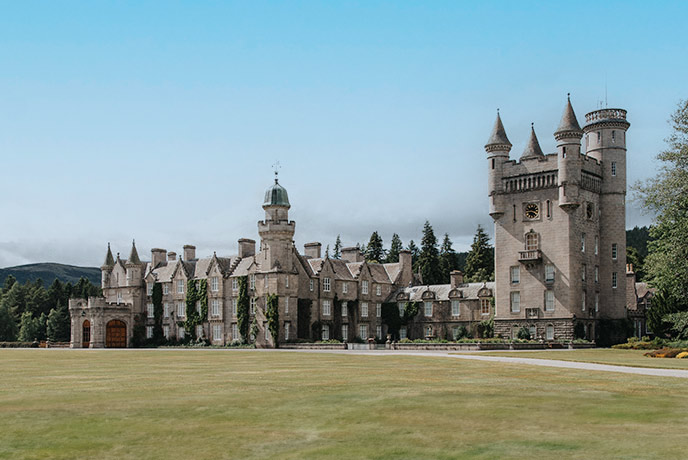 The historic castle of Balmoral surrounded by green lawns and trees in Scotland