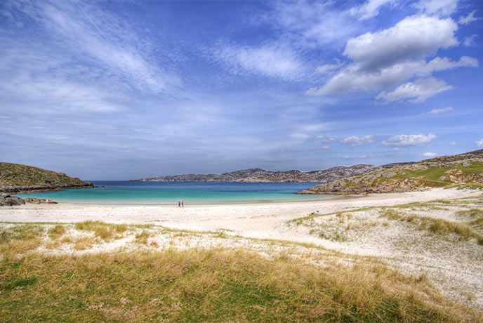 Looking out at the turquoise sea over white sands at Achmelvich beach in the Scottish Highlands