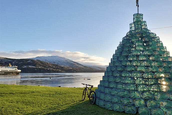A bike leaning against a tower of lobster nets in Ullapool