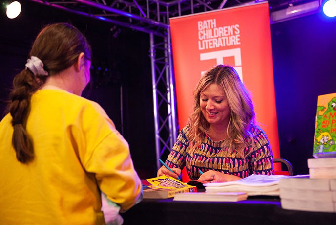 An author signing books at the Bath Children's Literature Festival