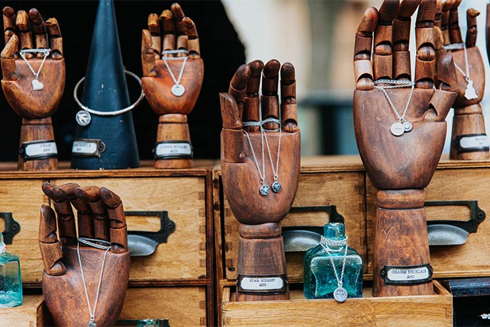 A selection of wooden hands holding necklaces at Frome Independent Market
