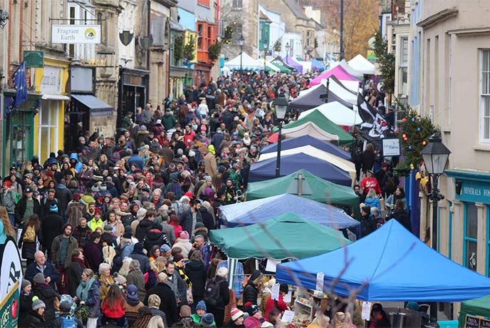 A busy street lined with stalls at the Frost Fayre in Glastonbury