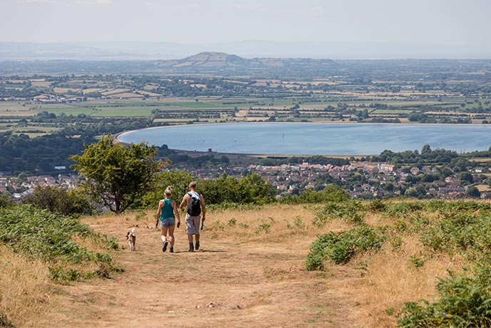 A couple walking with their dog at Cheddar Gorge, one of the best walks in Somerset