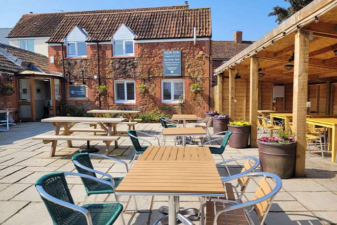 Outdoor tables in front of a red bricked exterior at The New Inn in Somerset