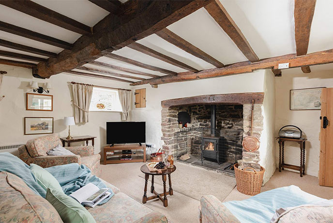 The cosy living room at Cleveland Cottage with exposed beams and a wood-burner