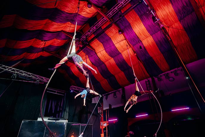 Circus performers hanging from ropes during a Halloween performance at Wookey Hole Caves in Somerset