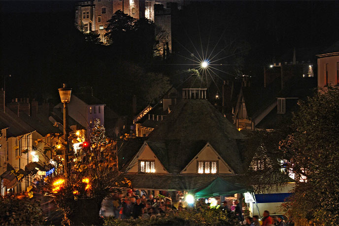 The town of Dunster at night lit up with Christmas decorations