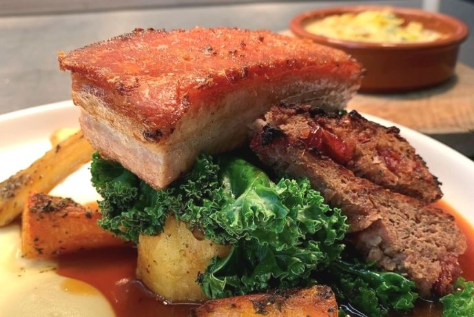 A close up on a plate of pork belly and vegetables at Chequers in Battle