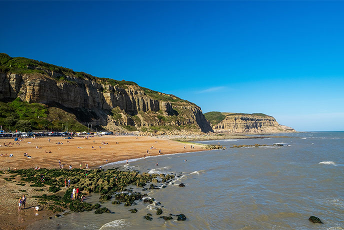 Golden sands and towering cliffs at Rock-a-Nore beach in Hastings Country Park