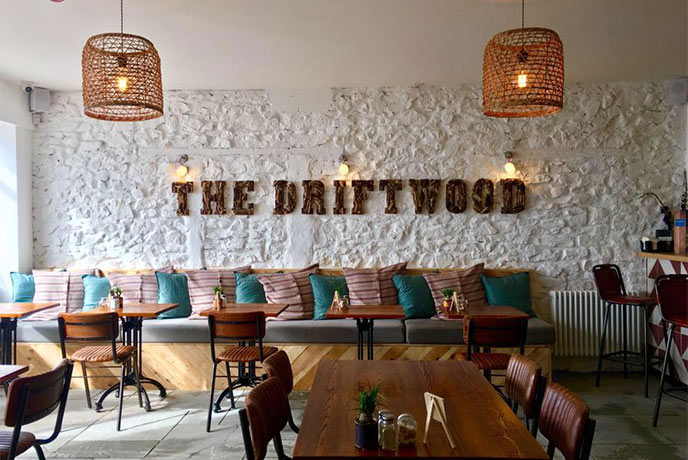 The modern dining area at The Driftwood with The Driftwood written on the wall