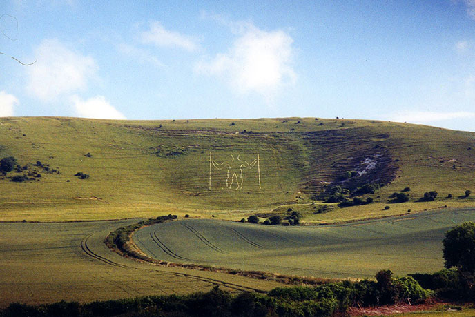 The chalk figure of the Long Man of Wilmington on a hillside in East Sussex