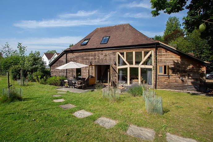 The pretty wooden exterior of Medleys Barn, one of the best dog-friendly holiday cottages in Sussex