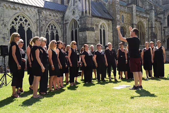 A choir performing in front of a church during Festival of Chichester in Sussex