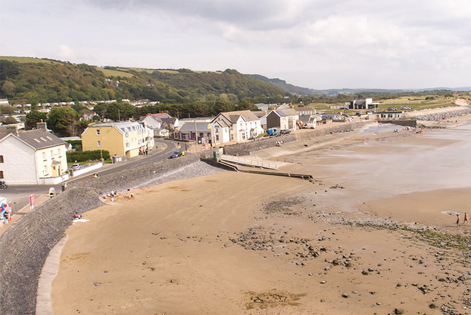 The stretching beach at Pendine Sands, backed by houses and a promenade