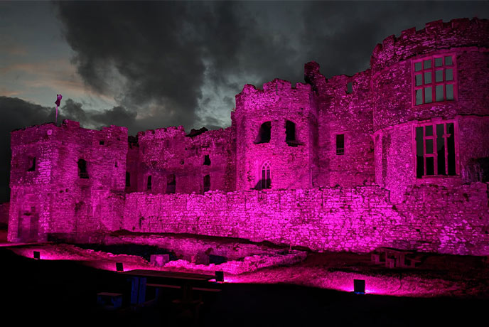 Carew Castle lit up by pink lights