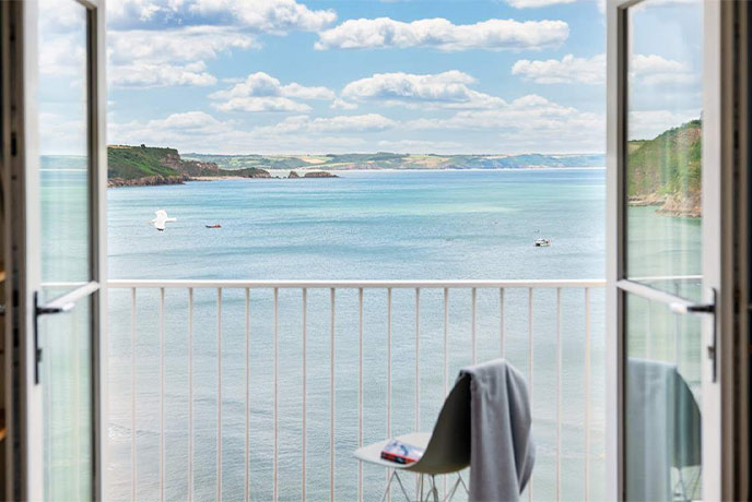 A chair on a balcony overlooking incredible sea views at a holiday cottage in Pembrokeshire