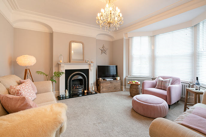 A pretty living room pink sofas and chairs at Pink Door at 54 in Pembrokeshire