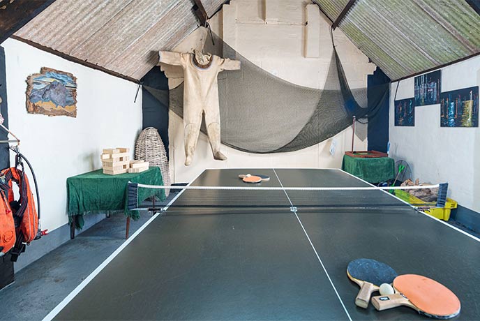 A ping pong table in a games room decorated with maritime relics