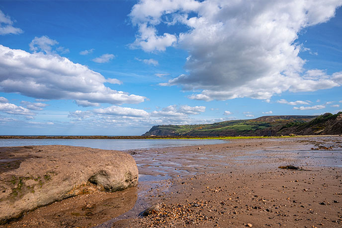 Looking across the golden sands at the headland at Robin Hood's Bay in Yorkshire
