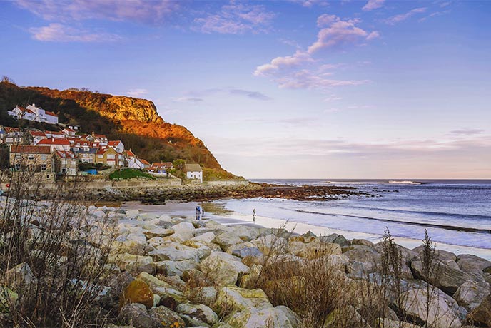 Looking across the rocks and sand of Runswick Bay at the beautiful village in Yorkshire