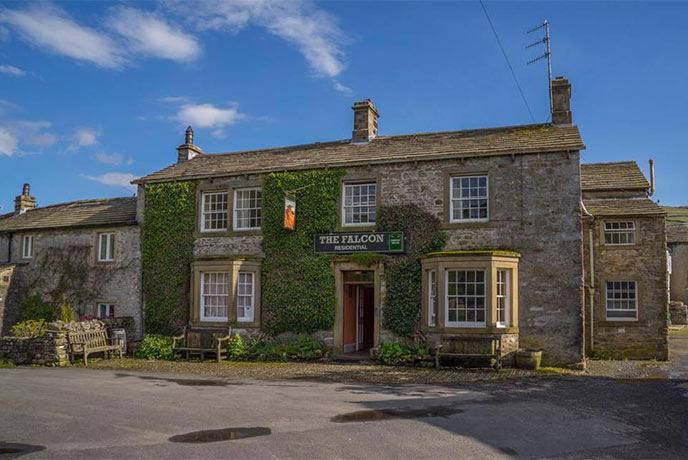 The traditional exterior of the Falcon Inn with ivy creeping up the front