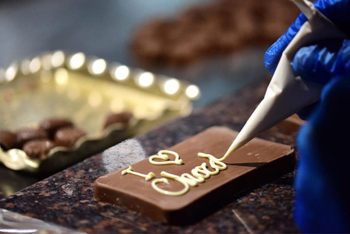 Someone decorating a piece of chocolate at York's Chocolate Story in Yorkshire