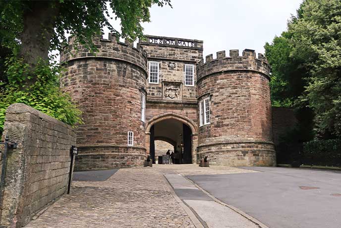 The historic entrance to Skipton Castle with a canon outside