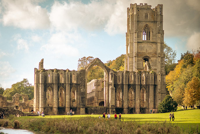 The beautiful ruins of Fountains Abbey in Yorkshire in autumn, surrounded by orange trees