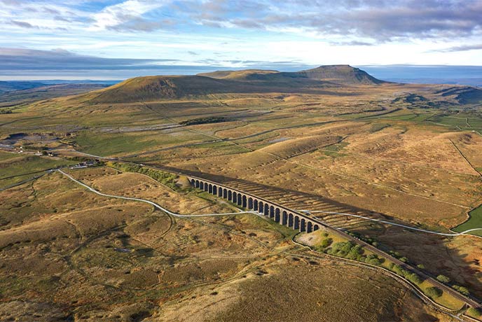 A bird's eye view of the Ribblehead Viaduct with the Three Peaks in the distance, one of the best walks in Yorkshire
