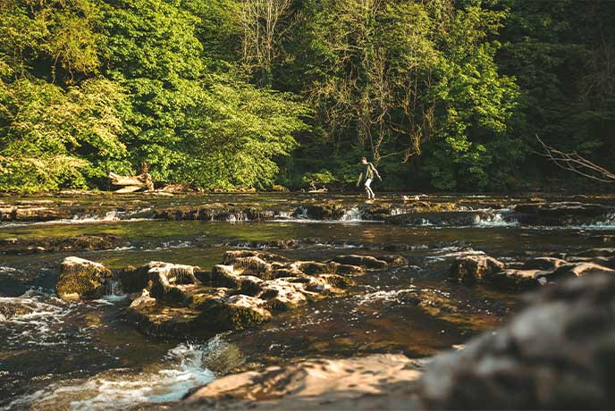 Someone walking across Aysgarth Falls in Yorkshire