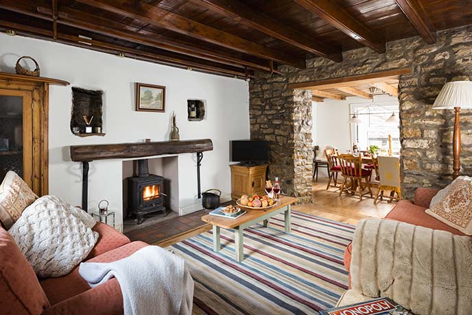 The cosy living room at Fell View in Yorkshire with a lit wood burner and cosy sofas