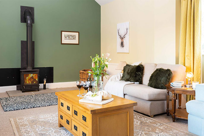 The colourful living room with a wood-burner at The Byre