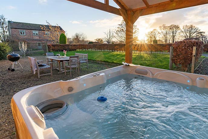 The sun setting over the beautiful garden and hot tub at The Stables in Yorkshire