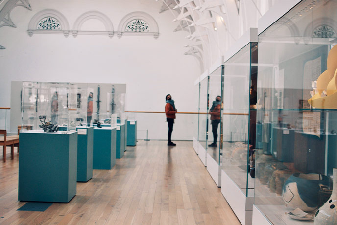 A person standing in an art gallery in Yorkshire looking at display cases