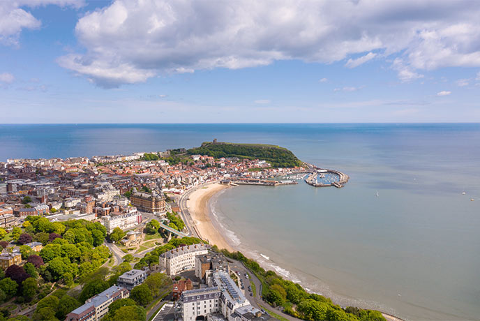 A bird's eye view of the seaside town of Scarborough with South Bay running alongside one side of the headland