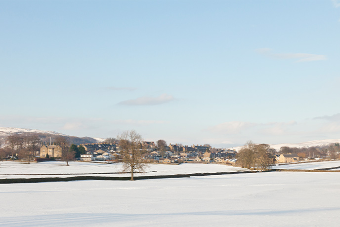 Looking out over fields covered in snow at the pretty village of Settle in Yorkshire